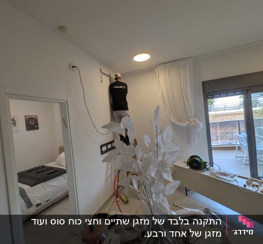 אדם מתקין מזגן על קיר בחדר מגורים